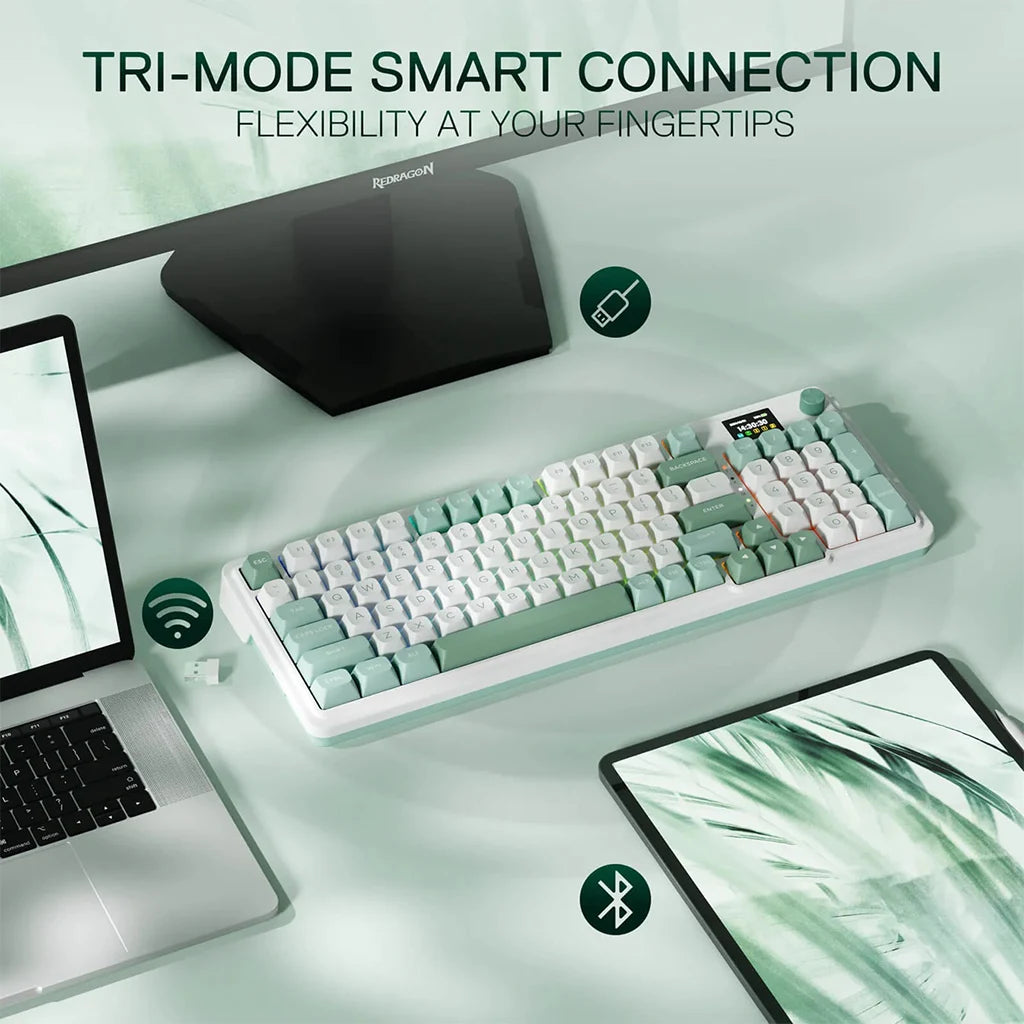 Keyboard with tri-mode smart connection features on a desk setup with laptop and tablet.