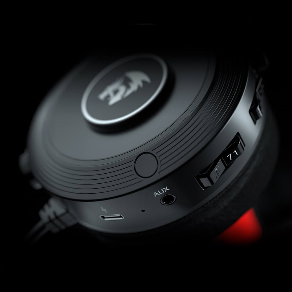 Earcup of Redragon H818 Pelops headset displaying power button, virtual 7.1 surround sound switch, AUX input & USB charging port