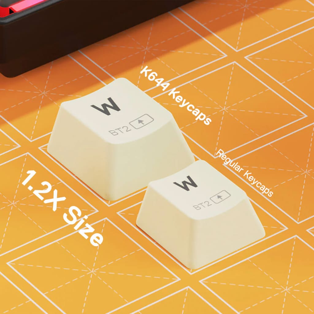 Close-up of Redragon K644 keycaps on an orange background, highlighting 1.2X size than a regular keycaps