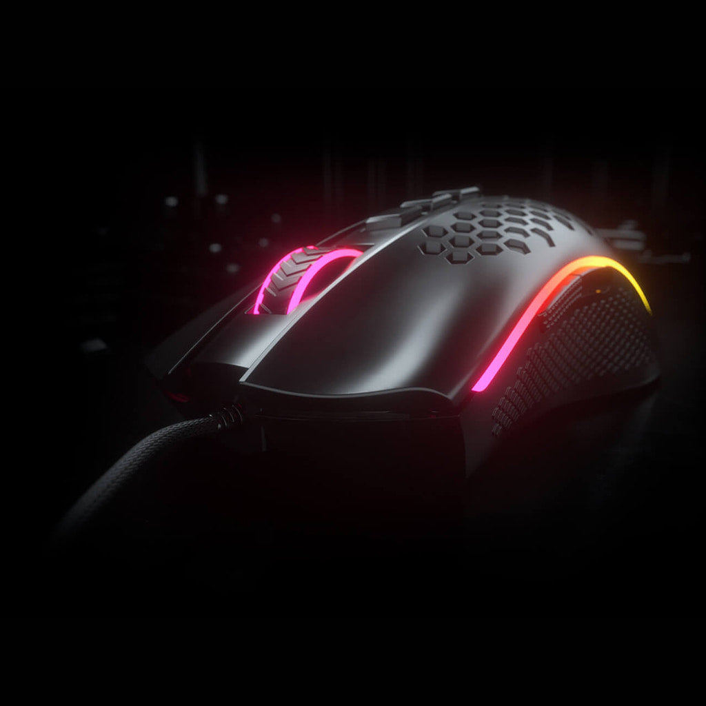 Redragon M988 Storm Elite Black mouse from a front-right angle in low light, showing honeycomb shell & illuminated RGB lighting