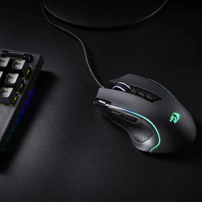 Redragon M612 Predator RGB Gaming Mouse from above, positioned next to a keyboard to show scale and on-desk appearance