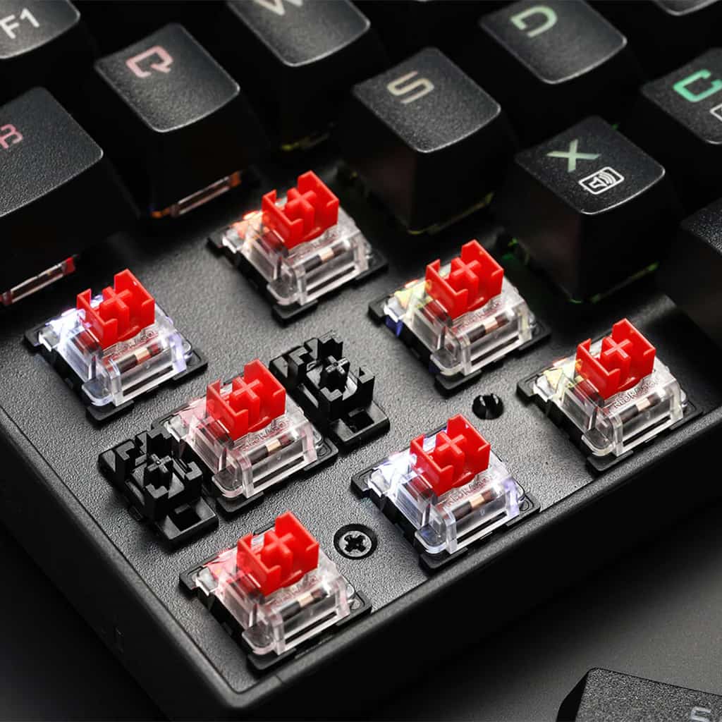 Close-up of several Redragon K599 Deimos mechanical keyboard switches and the base of removed keycaps, showing the RGB lighting